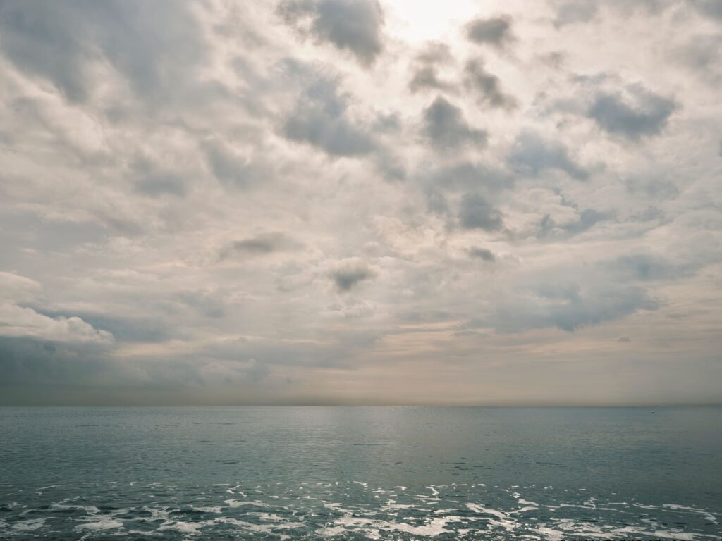 Peaceful view of the ocean under an overcast, cloudy sky creating a tranquil and calming atmosphere.