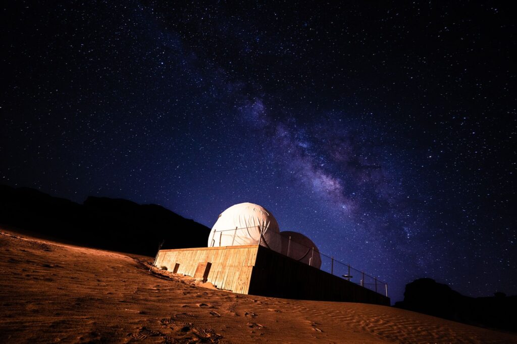 Stunning view of the Milky Way galaxy above a desert observatory under a starry night, an image for Science and Religion: Does Science Provide All the Answers