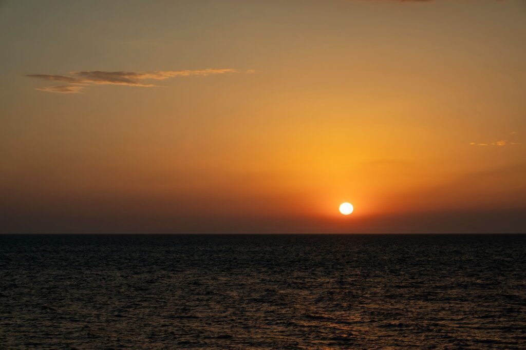 A breathtaking view of the sun setting over the ocean, creating an orange sky, an image for If Nothing Really Matters, Why Does It Feel Like It Should
