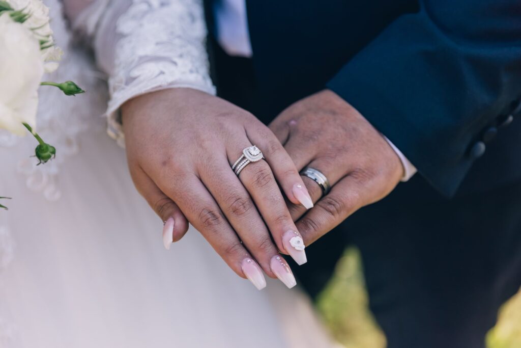 Close-up image of a couple's hands showing off diamond wedding rings, symbolizing love and marriage, an image for Quran 4 34: Does the Verse Permit a Husband to Beat His Wife