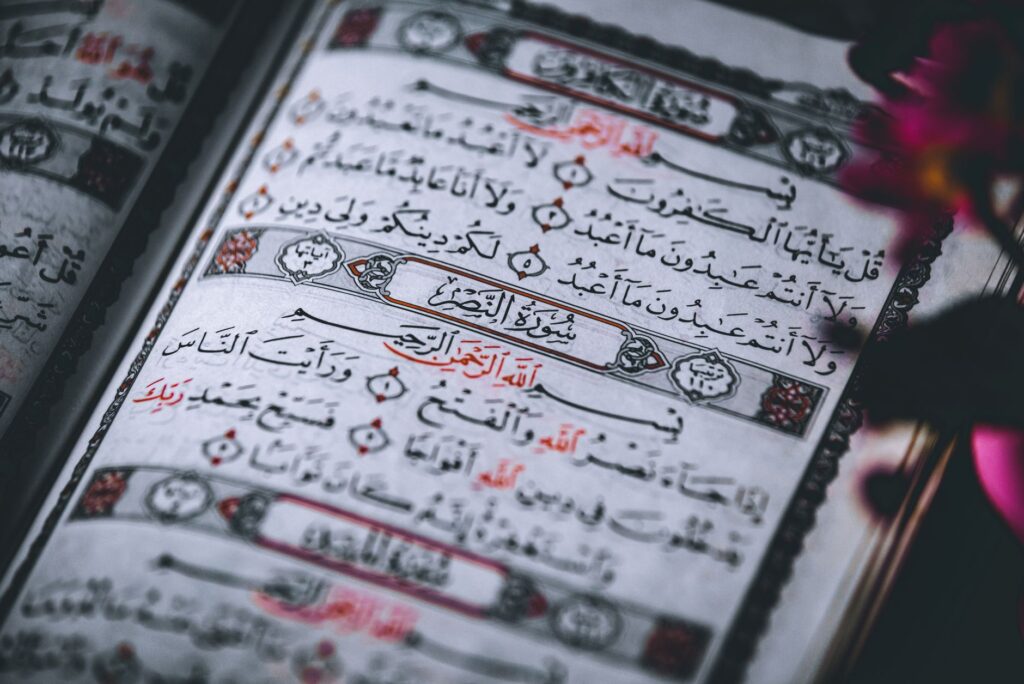 A detailed close-up of Quran pages featuring Arabic script, focusing on religious text and calligraphy.