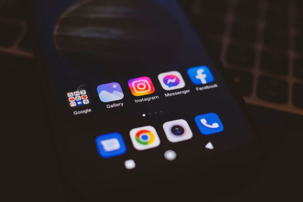 A smartphone displaying popular social media apps in a dimly lit environment, perfect for tech and communication themes, an image for The Algorithm That Deconverted You