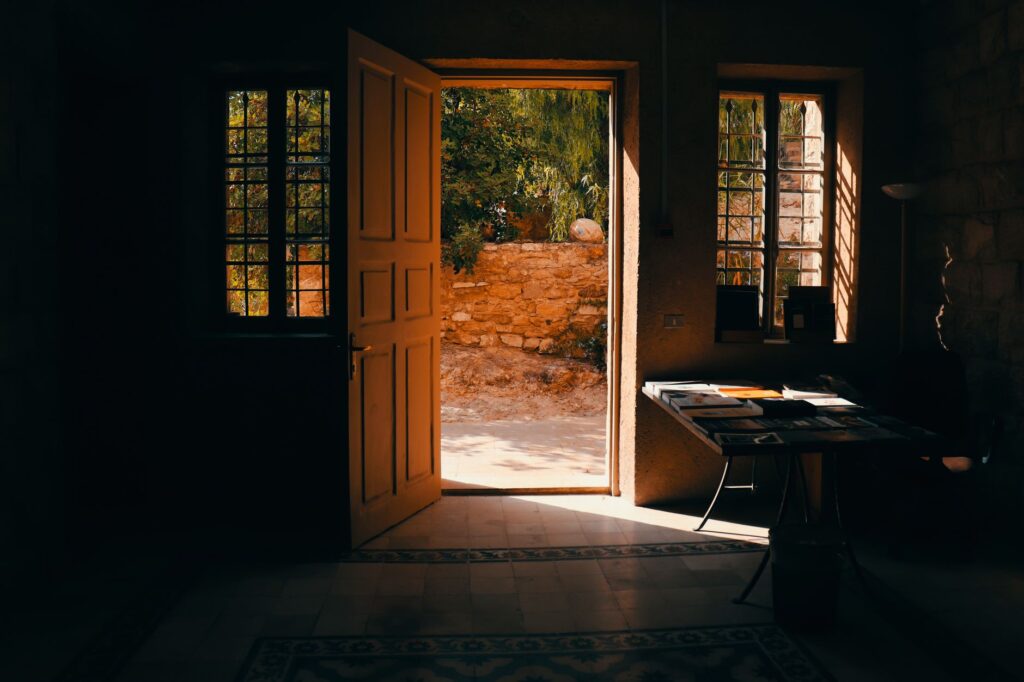 Warm sunlight streams through an open door in a traditional home interior in Amman, Jordan.