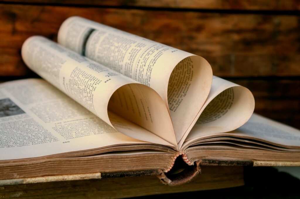 A vintage book with heart-shaped pages against a wooden background, symbolizing love for reading.