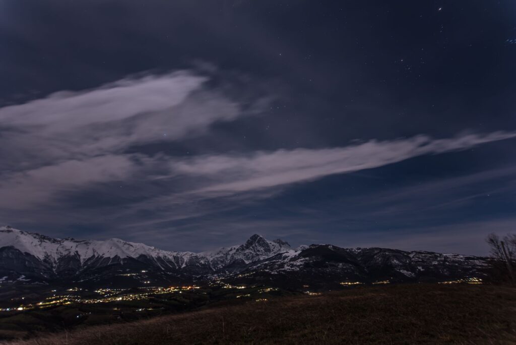 Scenic view of snow-capped mountains and a starry night sky, perfect for landscape enthusiasts.
