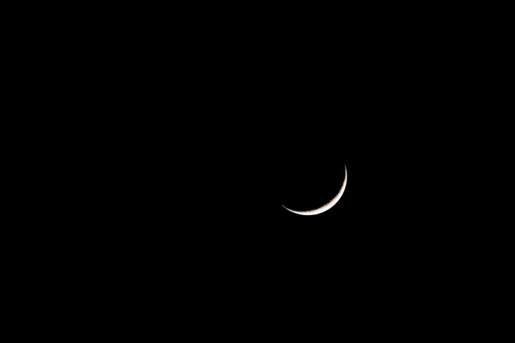 A striking image of a crescent moon set against a deep black sky, showcasing its serene beauty, an image for Is Allah a Moon God, or the God of Abraham