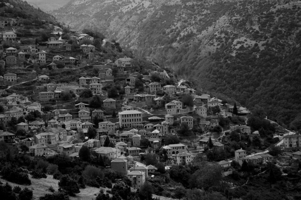 Aerial view of a mountain town with houses nestled on hills in black and white, an image for Honour Killings: Culture, Not Islam