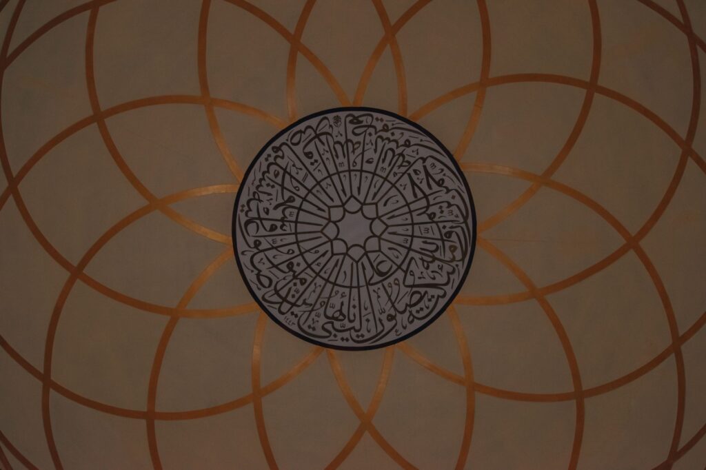 Intricate and ornate mosque dome featuring elegant Islamic calligraphy pattern.