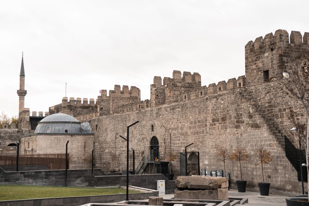 A historic castle with adjoining mosque, showcasing medieval architecture and autumn surroundings.