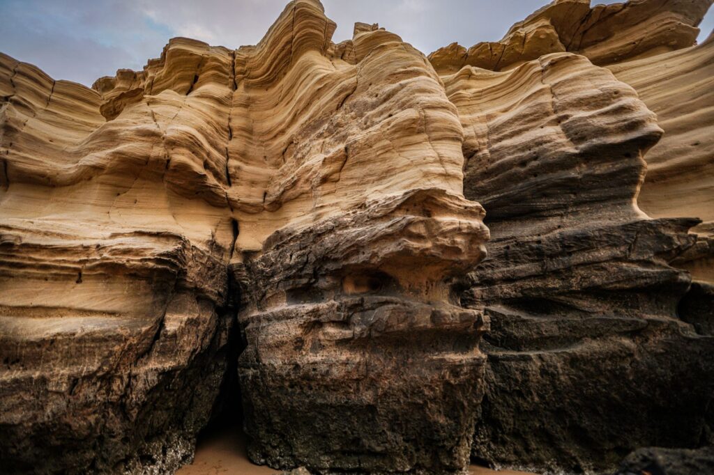 Close-up of layered sandstone formations in an arid landscape, showcasing natural erosion patterns.