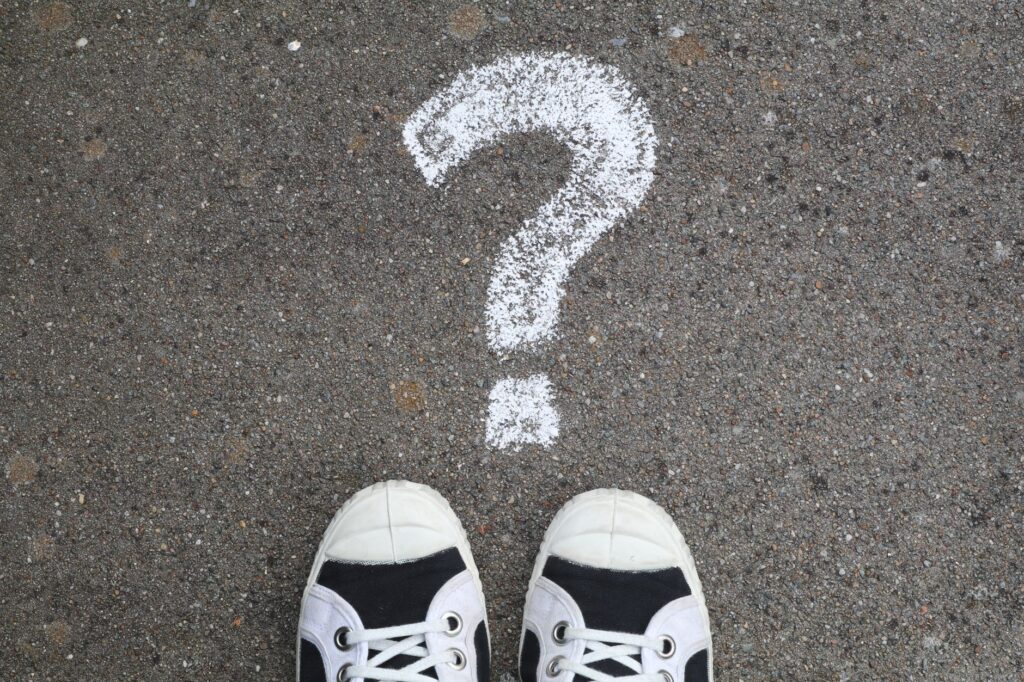 Sneakers on pavement with a chalk question mark, symbolizing curiosity or decisions, an image for Is Doubt Permitted in Islam