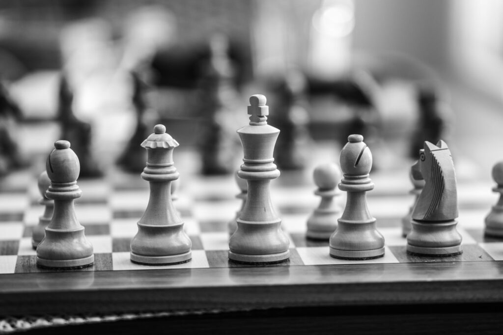 Black and white close-up of wooden chess pieces on a chessboard, emphasizing strategy and gameplay, an image for Objective Morality: Is Morality Just Opinion