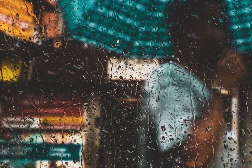 Blurred view through a rain-soaked window capturing the vibrant essence of Kolkata's streets.