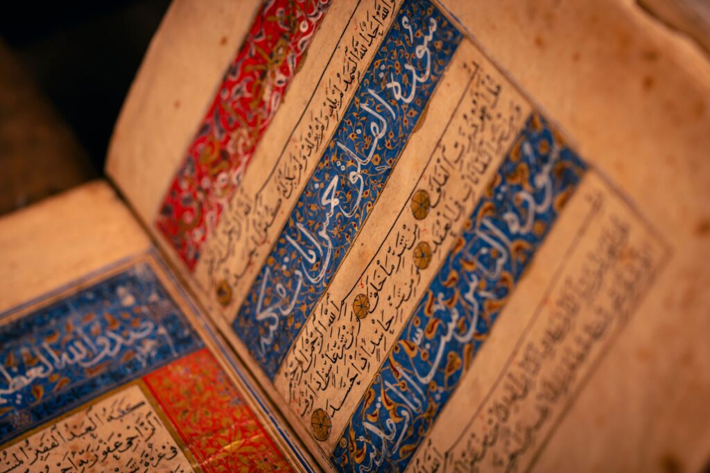 Detailed view of an ancient illuminated manuscript with Arabic script and intricate designs.