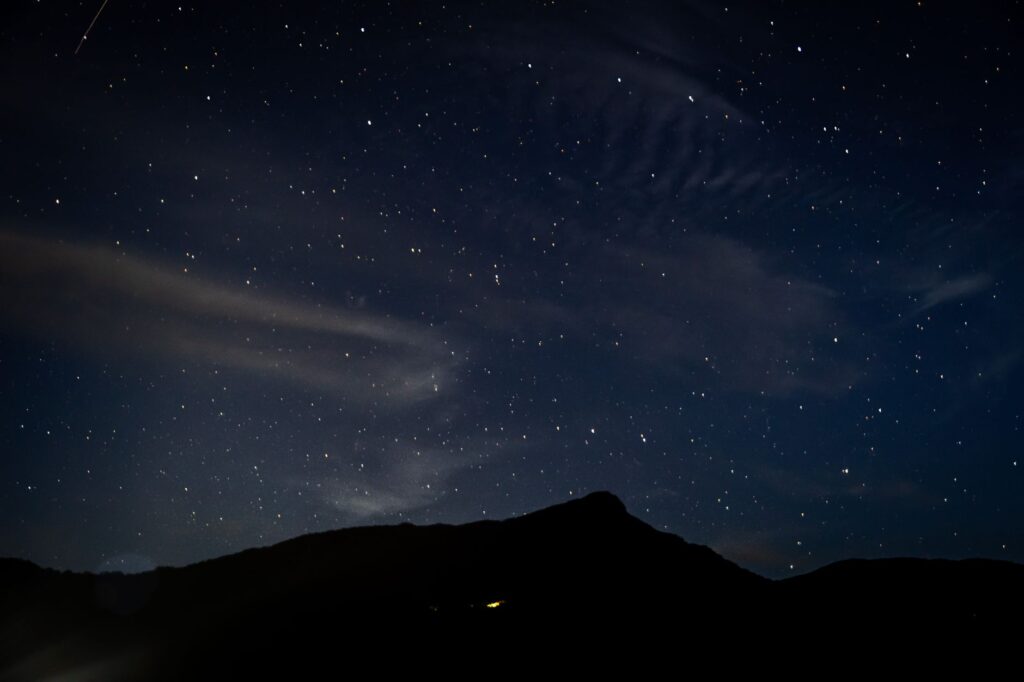 Beautiful star-filled night sky over a mountain silhouette, perfect for serene and cosmic themes.