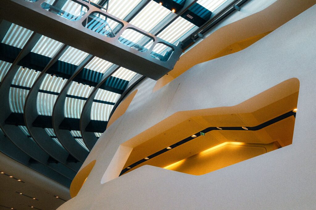 A stunning modern architectural ceiling with a curved skylight and unique lighting elements.