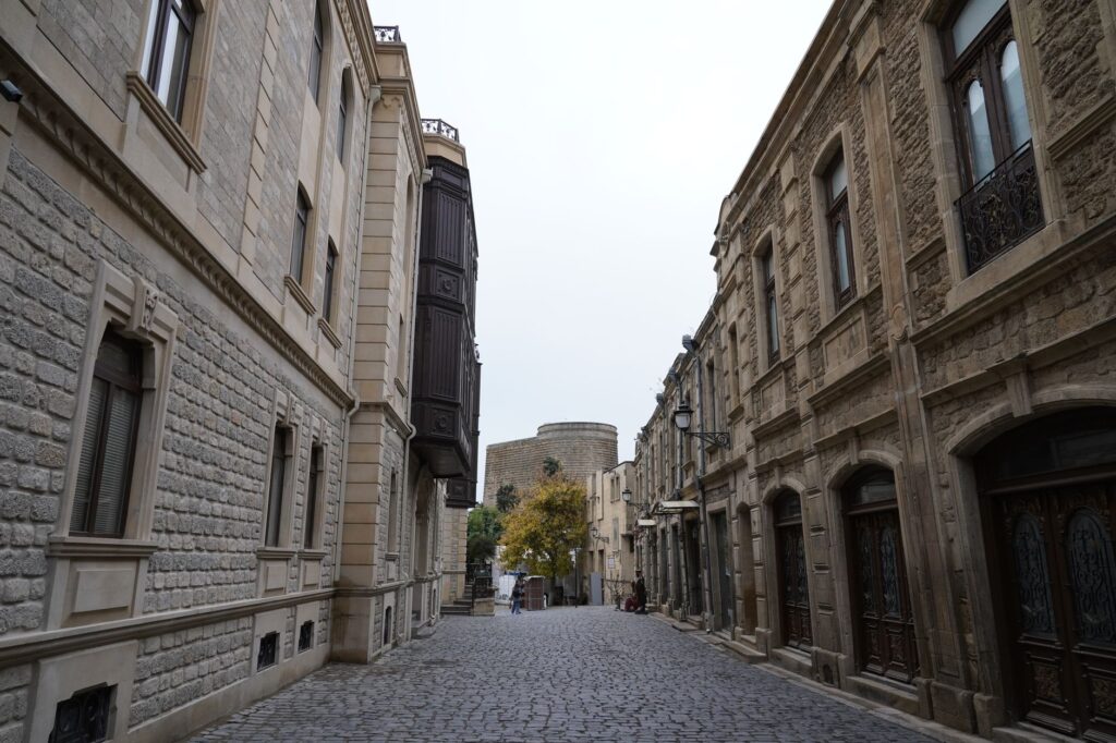 Capture of a cobblestone street in Baku's Old City, showcasing traditional stone architecture and the Maiden Tower.