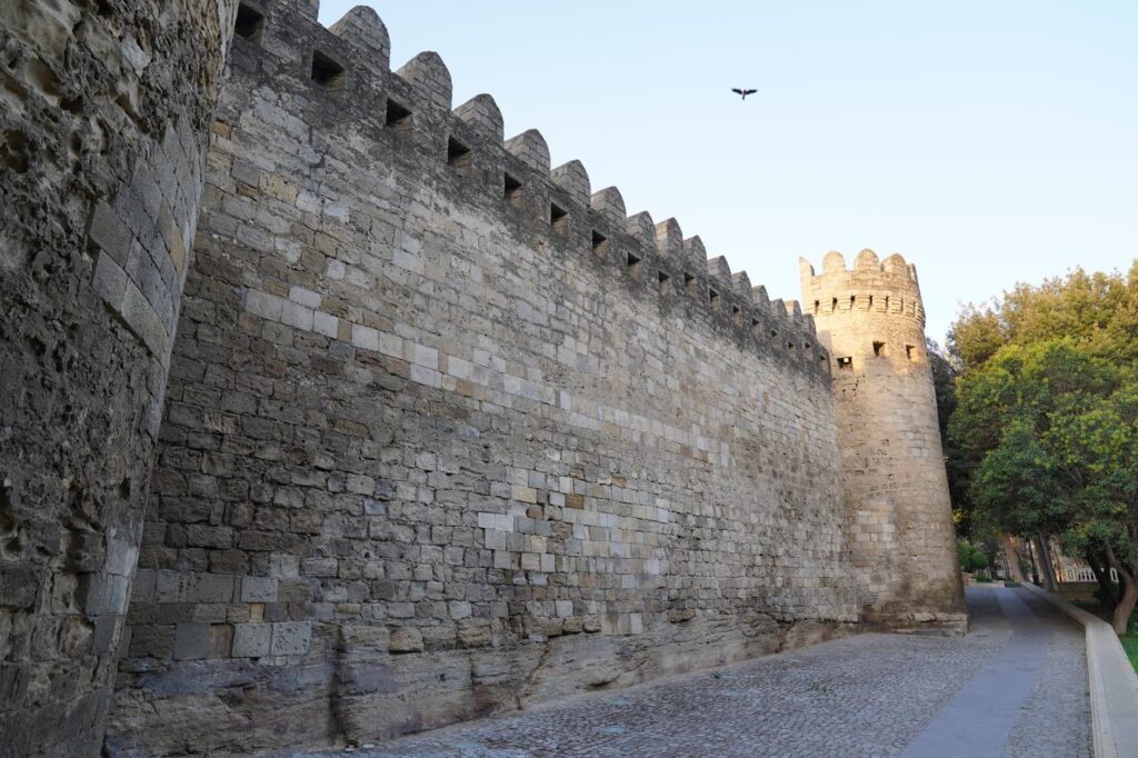 Ancient stone walls in Baku, Azerbaijan, showcasing medieval architecture with a serene twilight atmosphere.
