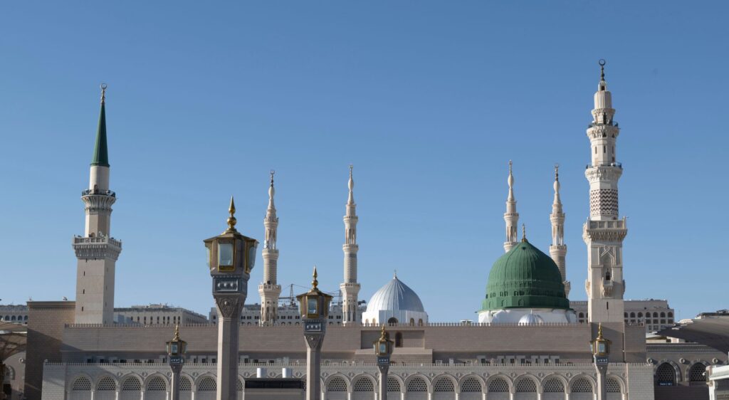 Stunning view of Al-Masjid an-Nabawi's minarets in Medina under blue skies.