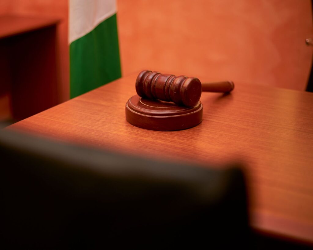 A close-up of a gavel on a courtroom desk representing law and justice, an image for Who Bears The Burden of Proof — The Theist or The Atheist