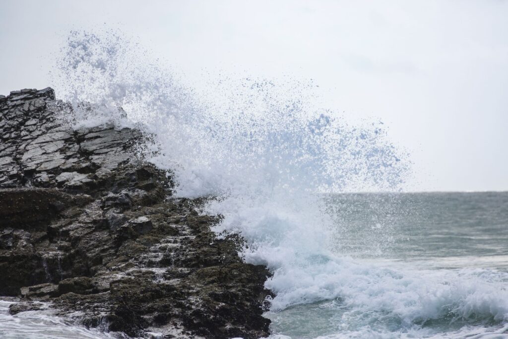 Waves powerfully crashing against rocky cliffs, showcasing the sea's strength and beauty, an image for Anger at Religion: What the Anger Phase Is and What It Means
