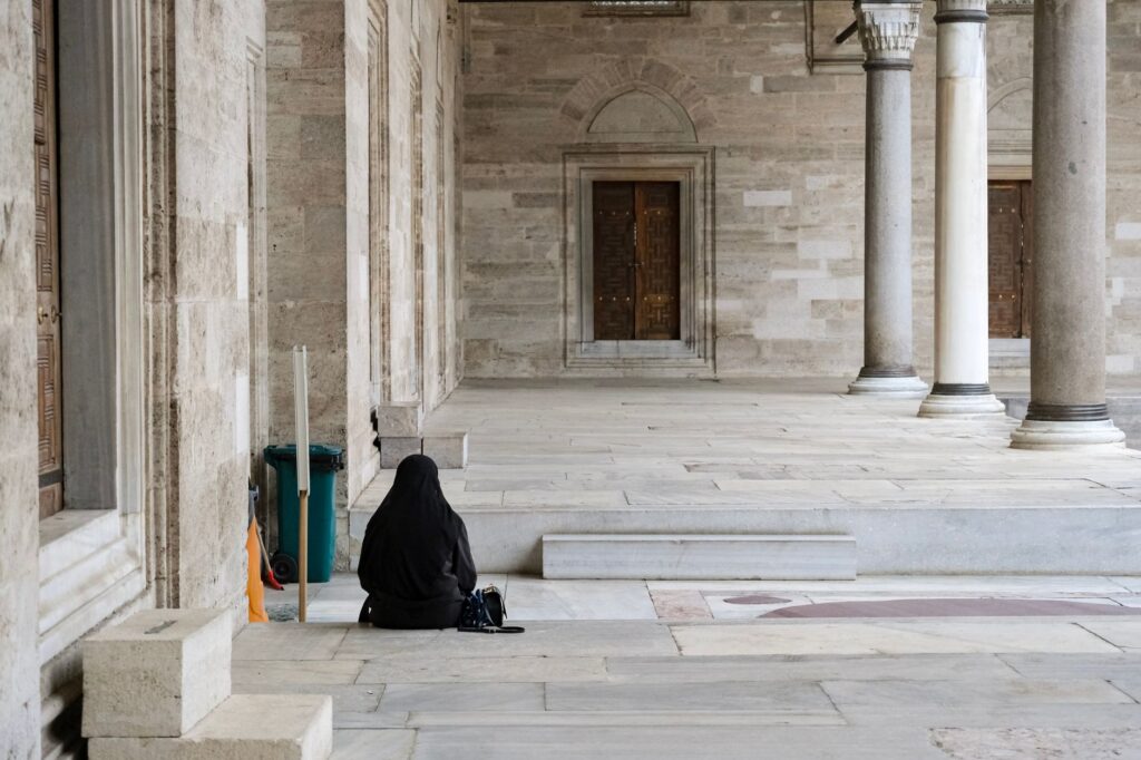 Lonely figure in Suleymaniye Mosque in Istanbul, highlighting architectural beauty.