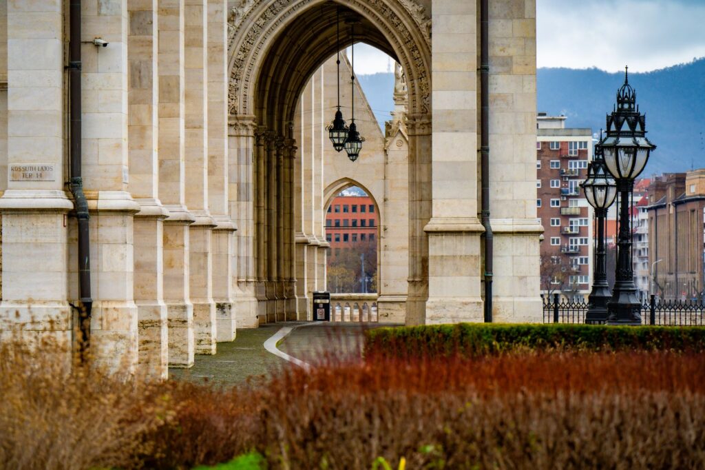 Gothic architectural details of the Budapest Parliament with street lamps in view.