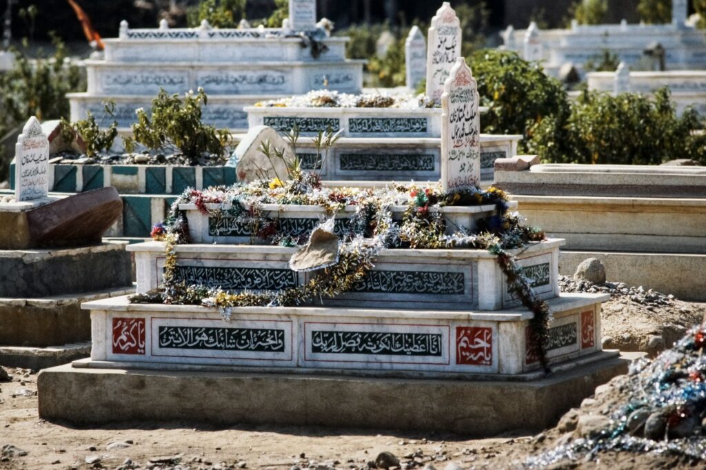 Decorated gravestone with intricate inscriptions in a Pakistani cemetery during the day, an image for After Death: What Does Islam Say Happens
