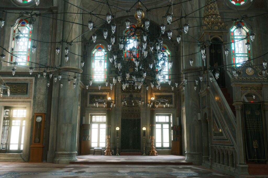 Stunning mosque interior featuring intricate chandeliers and stained glass windows.