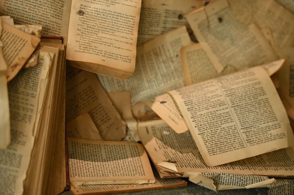 A collection of aged, open books with partially torn pages create a nostalgic atmosphere, an image for Hadith Authenticity: Can We Trust That Hadith Go Back to the Prophet