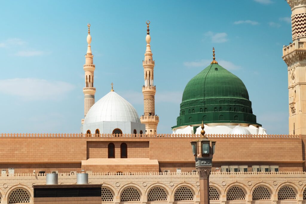 Beautiful view of the Prophet's Mosque in Madinah featuring its iconic green dome and minarets under a clear sky, an image for Banu Qurayza: The Violence of Early Islam and What It Means
