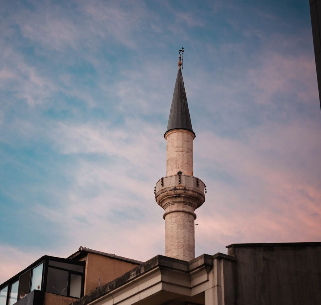 A picturesque minaret silhouetted against a colorful sunset sky, showcasing cultural architecture.