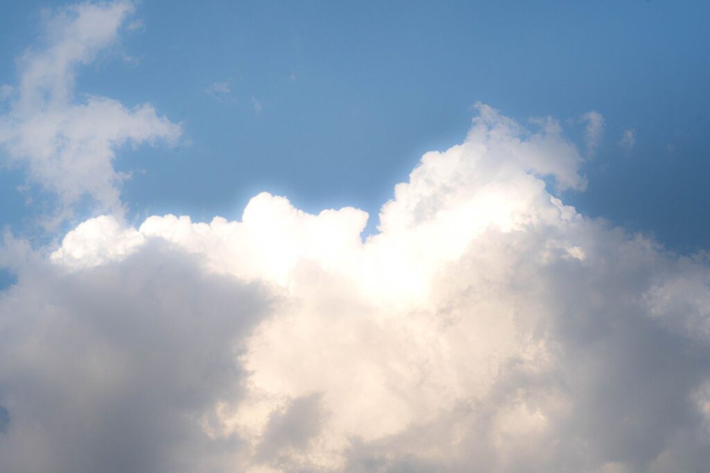 A serene view of fluffy white clouds against a vibrant blue sky, perfect for backgrounds.