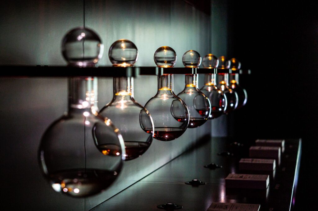 Artistic shot of lab flasks aligned on a reflective surface in low light