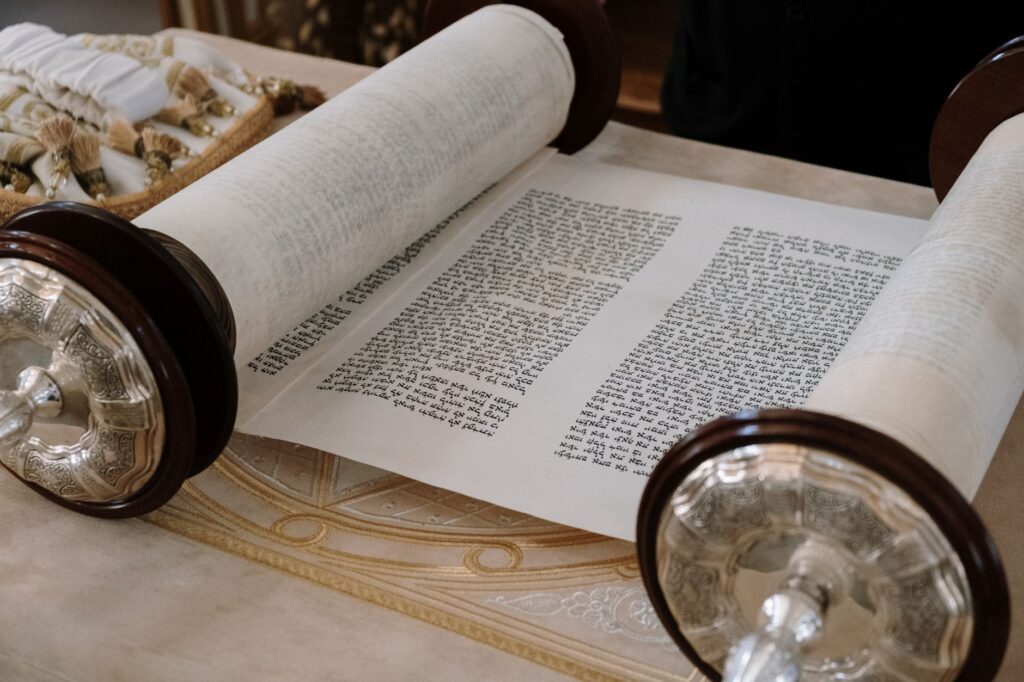 A close-up view of an open Sefer Torah on a synagogue table, highlighting intricate details, an image for What Would Authentic Revelation Look Like