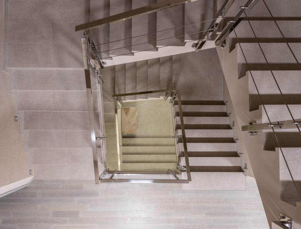 Top view flights of stairs with metal handrails and fencing located in light modern spacious multistory building with laminate floor, an image for Salvation by Works? Does Islam Teach That Paradise Is Earned