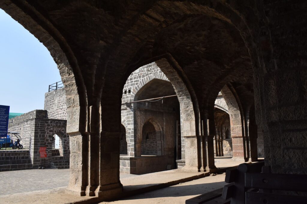 Stone arches in the historic Naldurg Fort, Maharashtra, showcasing medieval Indian architecture.