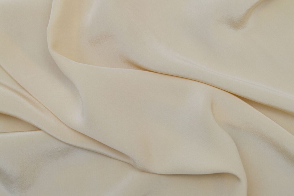 Detailed close-up image of beige fabric with soft, wavy texture.