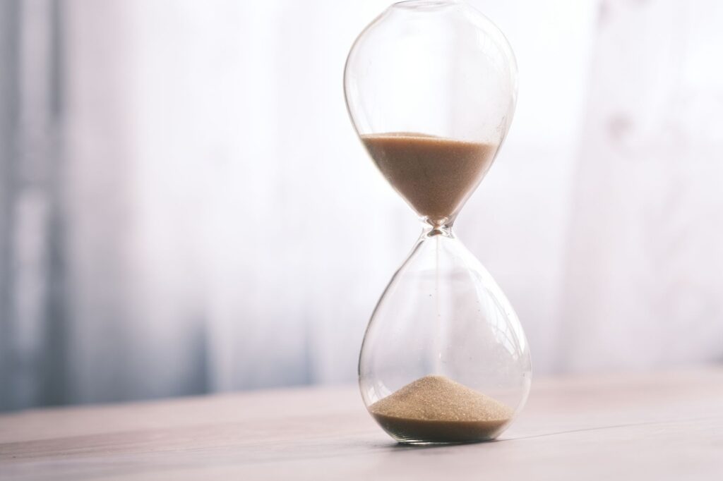 Minimalist hourglass filled with sand symbolizing time and patience, against a soft background, an image for Finite Sins, Infinite Punishment: Is Hell Proportionate