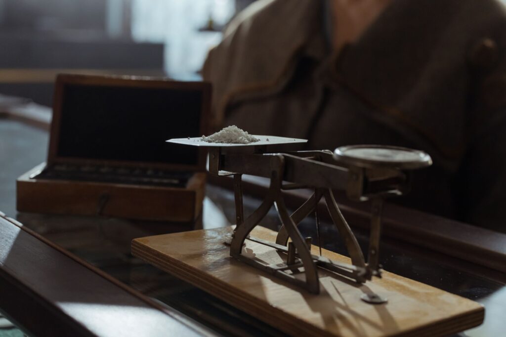 Classic vintage weighing scale with a small heap of white powder placed indoors on a wooden surface, an image for Competing Claims to Revelation: How Do We Evaluate Them