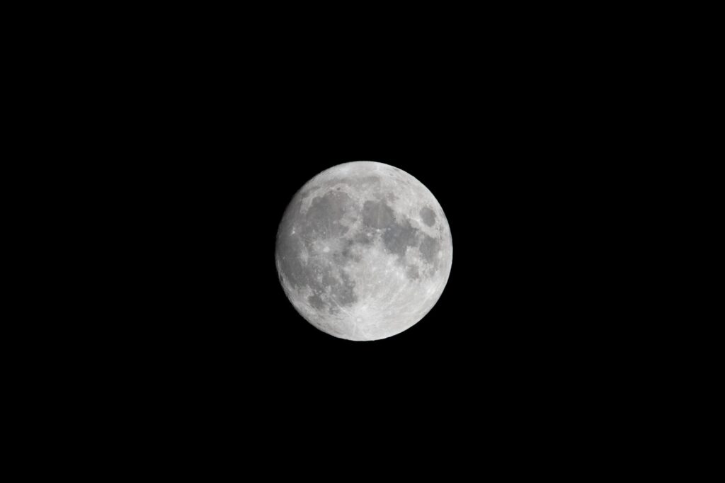 Close-up view of the full moon against a dark night sky, showcasing lunar details.